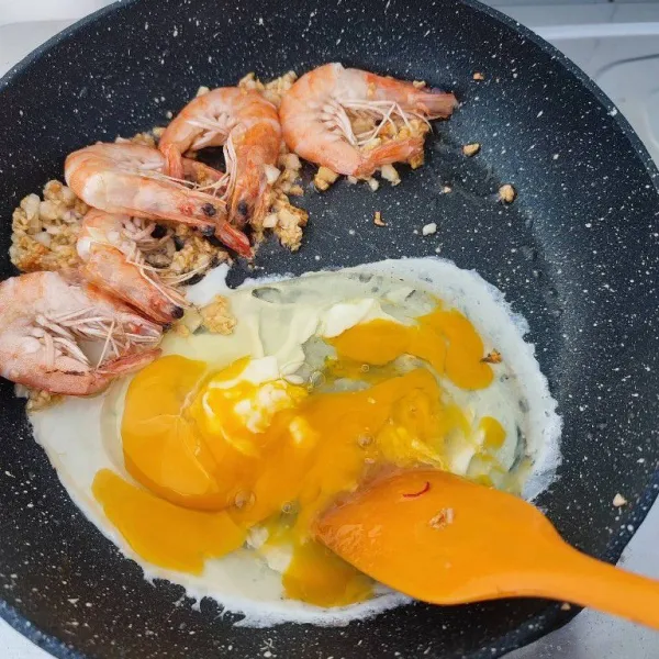 Sisihkan udang dan bawang putih ke tepi. Masukkan telur, kemudian orak-arik hingga matang.