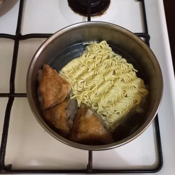 Masukkan mie rebus, masak hingga mie setengah matang.