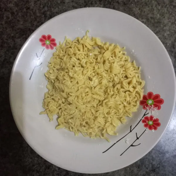 Remas mie instan kemudian rebus hingga setengah matang, tiriskan.