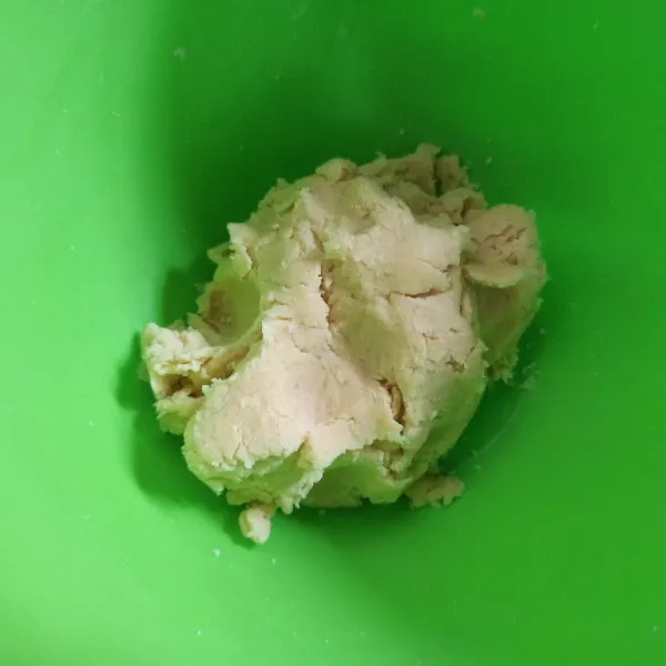 Selanjutnya masukkan air, aduk hingga tercampur rata, bulatkan adonan lalu tutup dengan plastik dan istirahatkan selama 10 menit.