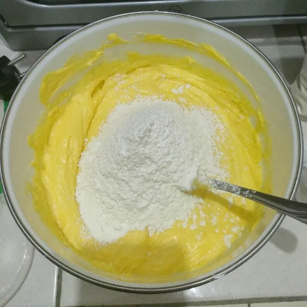 Setelah itu masukkan tepung, terigu, maizena, susu bubuk dan baking powder yang diayak. Aduk rata dengan spatula sampai adonan bisa dibentuk.