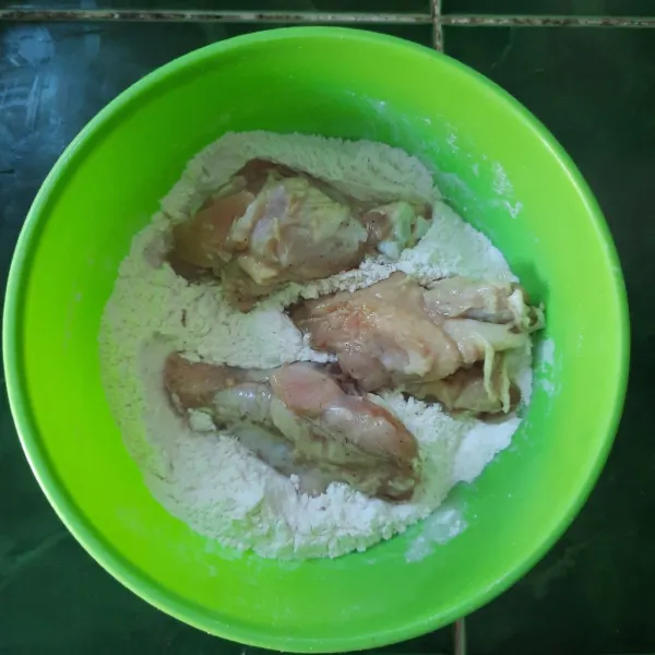 Baluri ayam dengan tepung kering sambil di remas-remas.