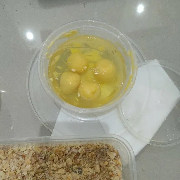 Ambil bulatan, lalu masukkan kedalam putih telur, angkat dan langsung gulingkan kedalam kacang tanah cincang. Lalu susun ke loyang.