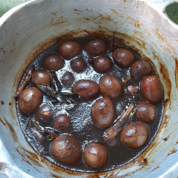 Setelah 2 jam, masukan telur beserta rendaman kecap cuka ke dalam bumbu halus, masak kembali, beri air, tambahkan gula, garam, masak sampai air berkurang. Biarkan semalam agar telur lebih padat dan cukup keras.