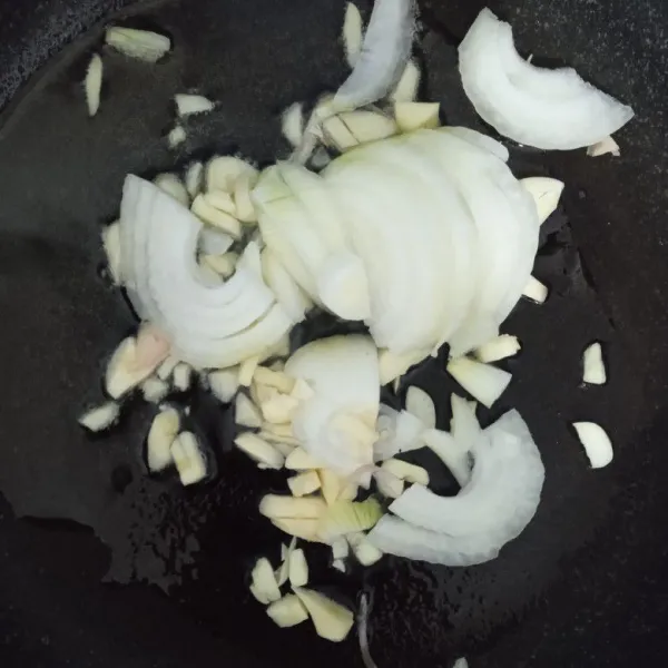 Panaskan minyak lalu tumis bombay dan bawang putih hingga harum.