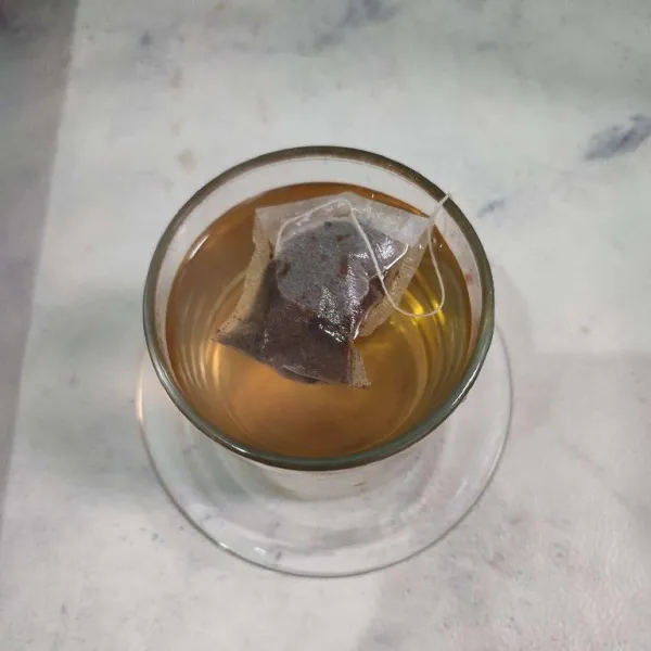 Tuang air panas ke dalam gelas berisi teh, biarkan hingga berwarna pekat.