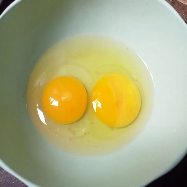 Pecahkan dua butir telur.