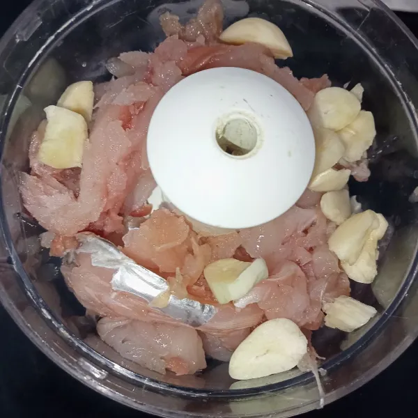 Masukkan tenggiri, bawang putih dan air es ke dalam food processor.