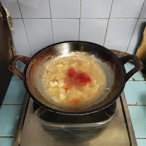 Tuang air dan saus tomat. Masak hingga mendidih.