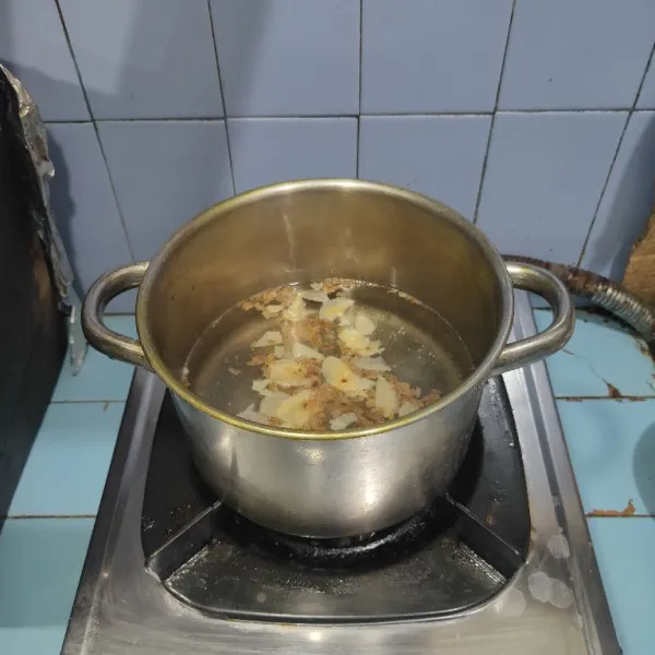 Siapkan panci, rebus air hingga mendidih. Lalu masukkan bawang merah dan bawang putih goreng.