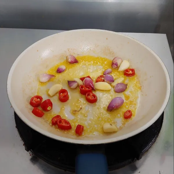 Dengan sisa mentega, tumis bawang putih, bawang merah, cabe merah, hingga layu.