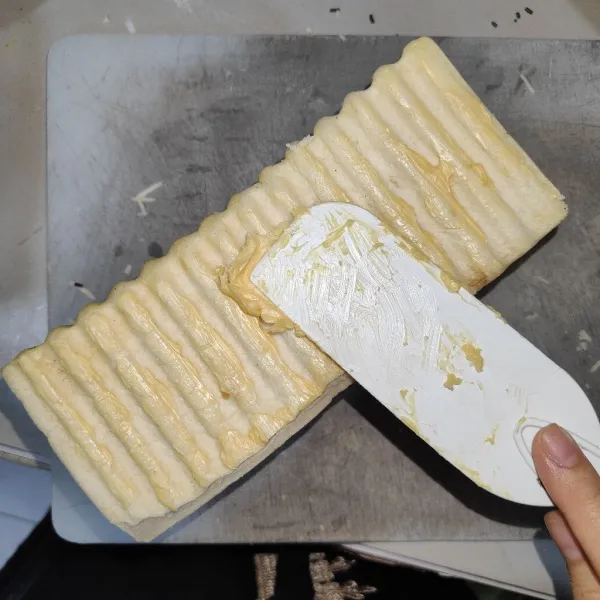 Olesi bagian luar roti dengan margarin.