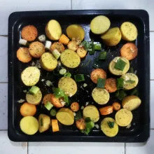 Taruh potongan baby potato, bawang pre, bawang putih, dan wortel di atas loyang, tuangkan minyak zaitun diatasnya secara merata dan taburi dengan garam dan lada hitam..