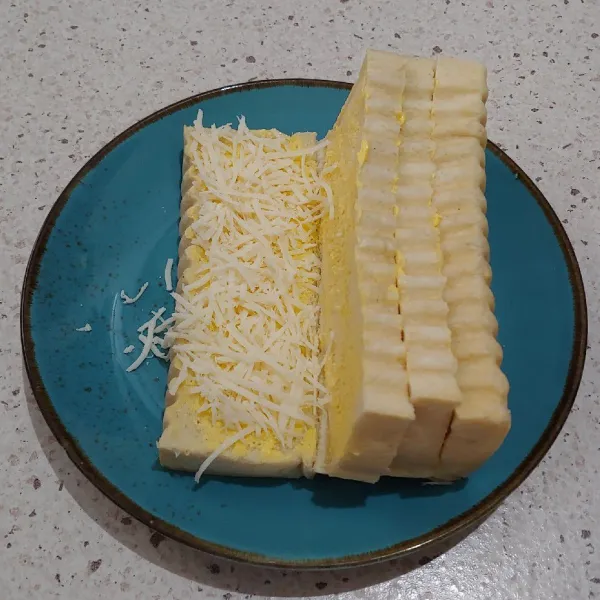 Oleskan sisi dalamnya dengan margarin, taburi dengan messes dan keju.