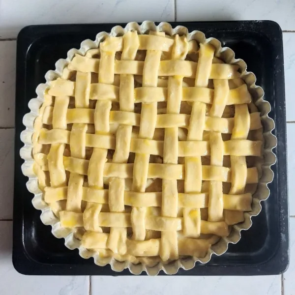 Campur kuning telur dengan air, lalu oleskan ke atas permukaan pie. Panggang di oven yang telah dipanaskan dengan suhu 200 derajat celcius dan dengan suhu 180 derajat celcius selama 20-15 menit. Apple Custard pie siap disajikan.