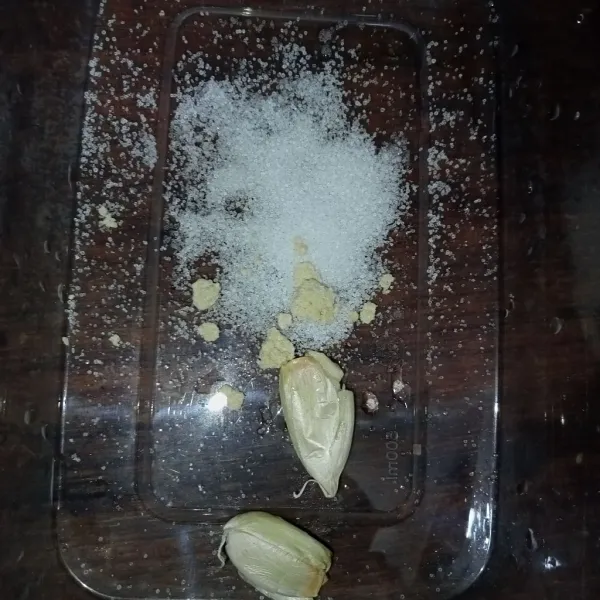 Dalam wadah tuang garam, kaldu jamur, bawang putih bubuk dan bawang putih geprek (bumbu marinasi).