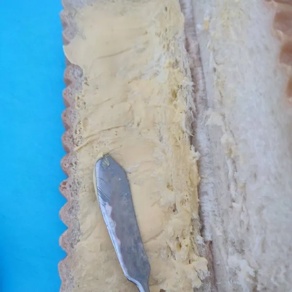 Buka sisi tepi, oles salah satu bagian dengan margarin hingga rata.