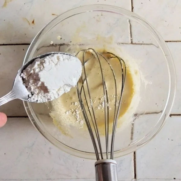 Masukkan kuning telur, kocok bersama dengan gula hingga rata dan mencair. Tambahkan tepung dan aduk kembali.