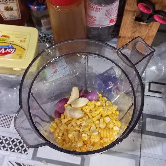Campurkan bawang merah, bawang putih, wortel, jagung dan tahu ke dalam blender.
