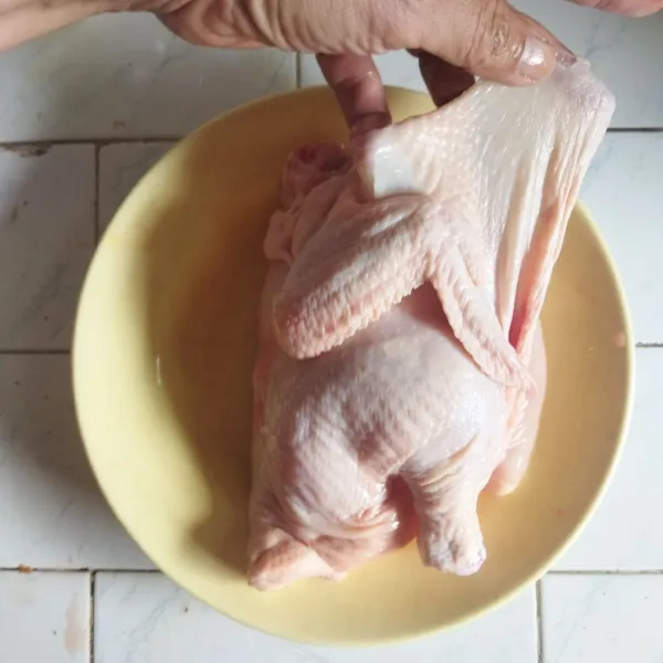 Keringkan permukaan ayam yang sudah dimarinasi sebelumnya dengan tisu. Lalu pisahkan bagian kulit dan daging menggunakan jari, usahakan jangan sampai merobek kulitnya.
