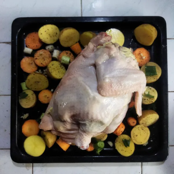 Kemudian letakkan ayam utuh di atas sayur. Panggang ayam di dalam oven dengan suhu 200 C selama kurang lebih 1 jam, sambil sesekali ayam dan sayur siram dengan bumbunya. Setelah matang, angkat dan sajikan.
