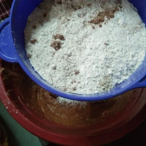 Ayak tepung terigu, baking powder, kayu manis bubuk, rempah bubuk, diatas adonan basah, beri garam.