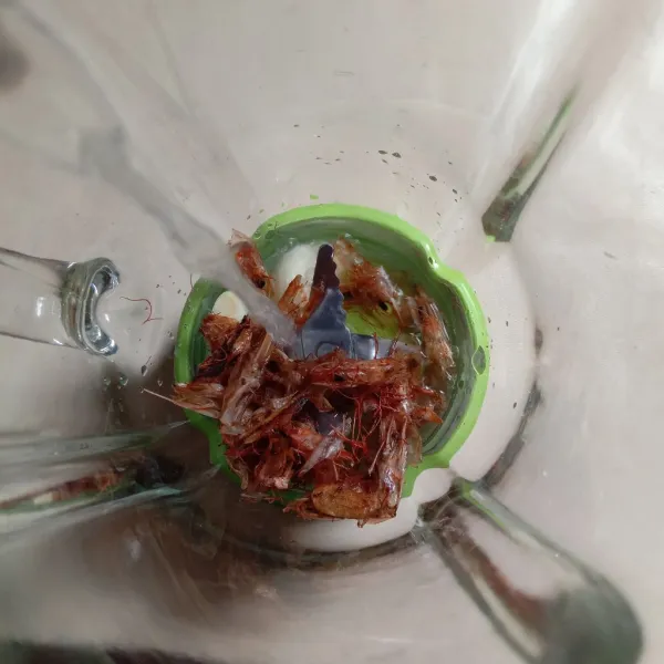 Kita buat adonan pempeknya terlebih dulu. Masukkan kepala udang sangrai, bawang putih, dan air ke dalam gelas blender, haluskan sampai benar-benar halus.