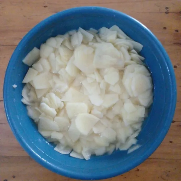 Sementara itu, bersihkan kentang kemudian iris tipis-tipis.