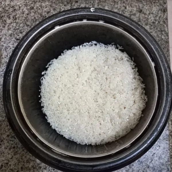 Cuci bersih beras putih.