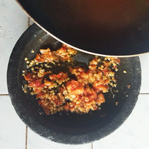 Tumis terasi, cabai rawit, bawang putih, tomat hingga lembut. Angkat dan letakan dalam ulekan, tambahkan garam, gula dan haluskan, koreksi rasa.