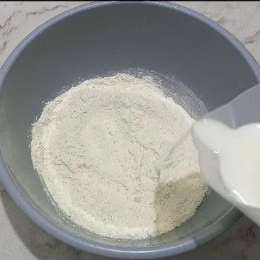 Di wadah campur terigu, ragi, gula pasir tuang susu secara bertahap uleni sampai setengah kalis.