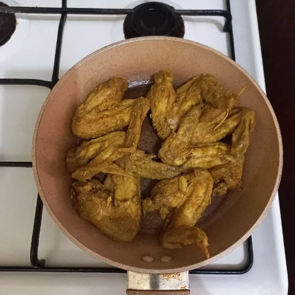 Tata sayap ayam pada teflon, nyalakan kompor dengan api kecil.