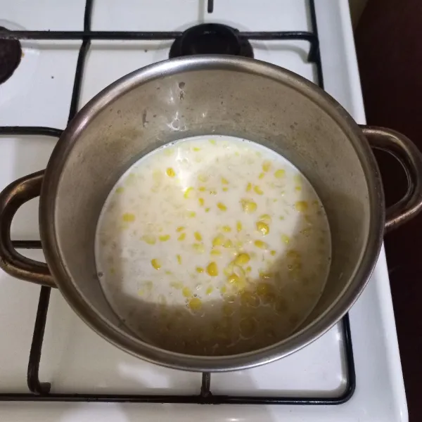 Tuang pipilan jagung rebus ke dalam panci, aduk rata lalu koreksi rasa.