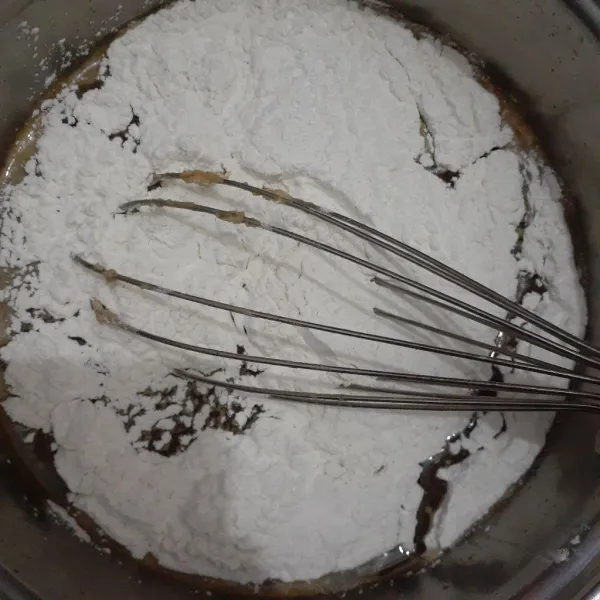 Masukkan tepung ketan secara bertahap pada larutan gula dan aduk dengan balloon whisk hingga larut.