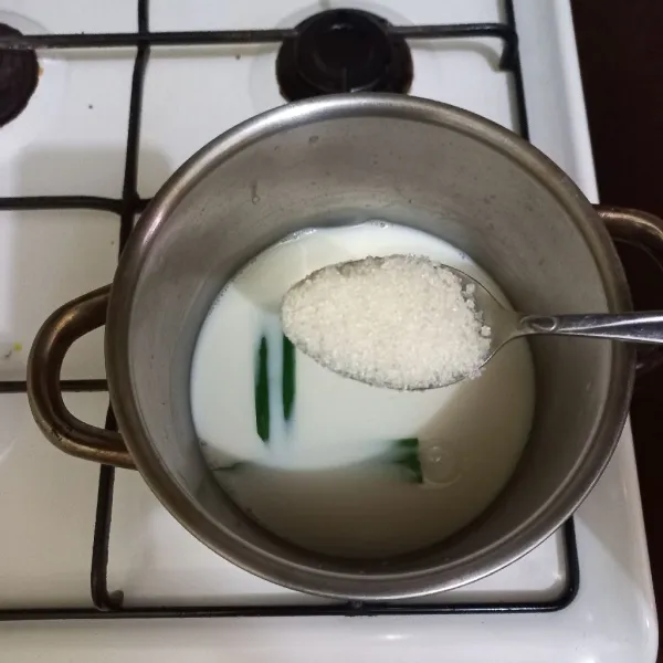 Didihkan susu cair bersama daun pandan, tambahkan gula pasir, aduk rata.