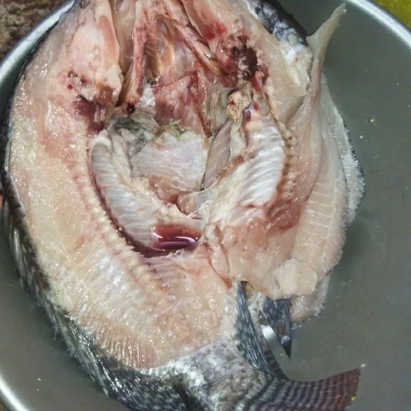 Bersihkan ikan nila, lalu belah ikan tapi tidak sampai putus, cuci bersih lalu beri air perasan jeruk nipis, aduk rata, sisihkan.