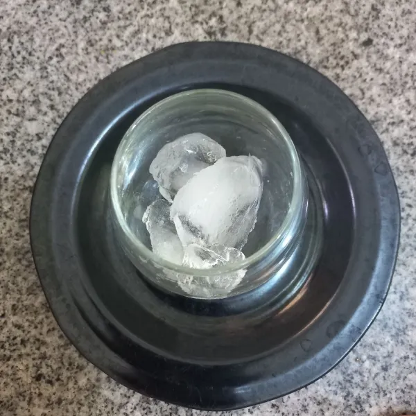 Siapkan gelas, masukan pecahan es batu ke dalamnya.