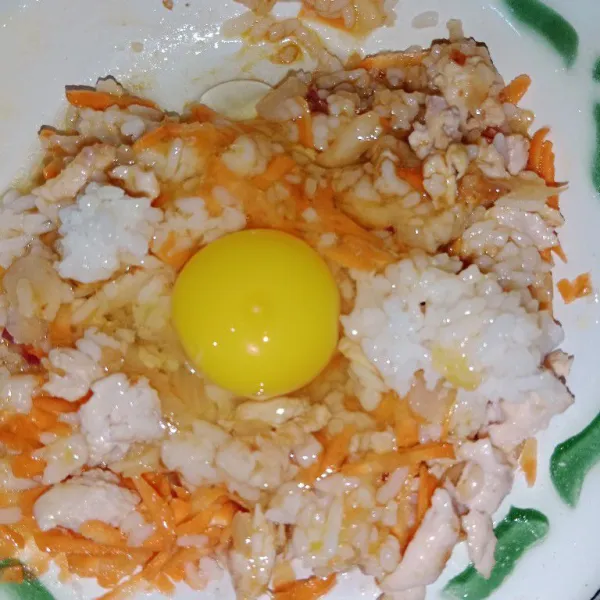 Dalam wadah masukan tumisan ayam, nasi, telur, wortel, kaldu bubuk dan kecap asin.