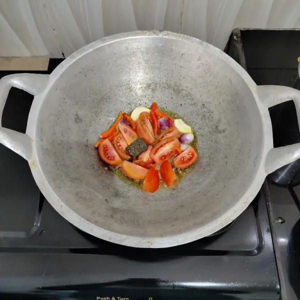 Goreng cabai rawit, bawang merah, bawang putih, tomat dan terasi hingga layu.