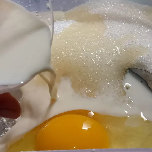 Tambahkan telur, gula pasir. Masukkan Secara perlahan susu cair sambil diaduk.