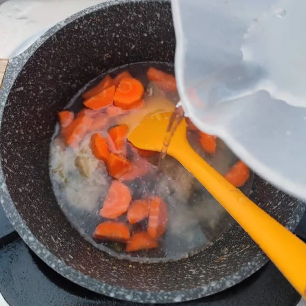 Masukkan wortel dan 200 ml air. Rebus hingga wortel empuk.