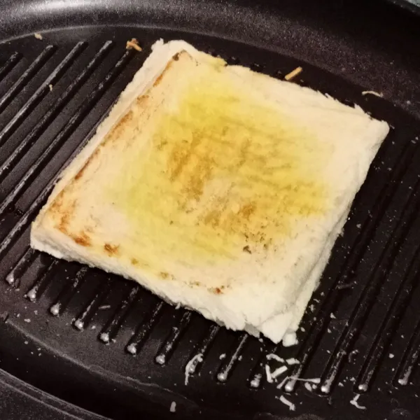 Tutup dengan 1 lembar roti tawar lagi. Kemudian panggang di kedua sisinya.