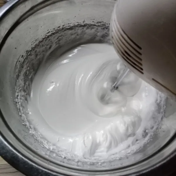 Masukkan gula pasir secara bertahap, mixer lagi sampai softpeak.