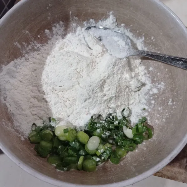 Masukkan tepung, irisan daun bawang, garam, kaldu bubuk, ketumbar bubuk, dan bawang putih halus ke dalam wadah.