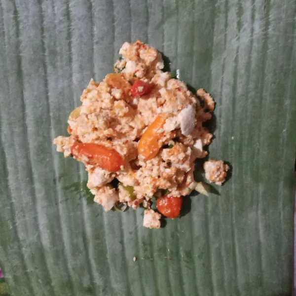 Ambil selembar daun pisang, beri 2 sendok makan adonan. Bungkus.