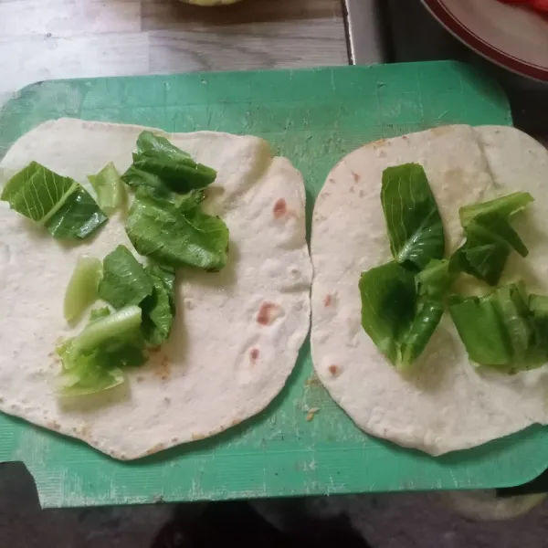 Penyelesaian: tata daun selada di atas kulit kebab.
