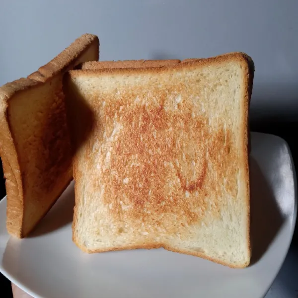 Panaskan wajan dengan api kecil. Panggang sambil dibolak-balik sampai permukaannya kecoklatan dan crispy. Tips : Angkat dan dinginkan dengan posisi berdiri agar roti panggang tetap crispy dan tidak lembab bagian bawahnya.