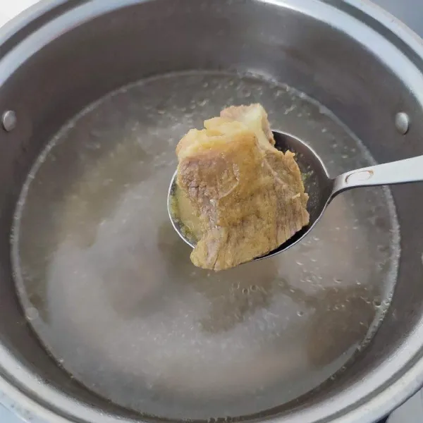 Kemudian masukkan bumbu tumis dan daging ke dalam air rebusan daging. Tambahkan air hingga ¾ tinggi panci.