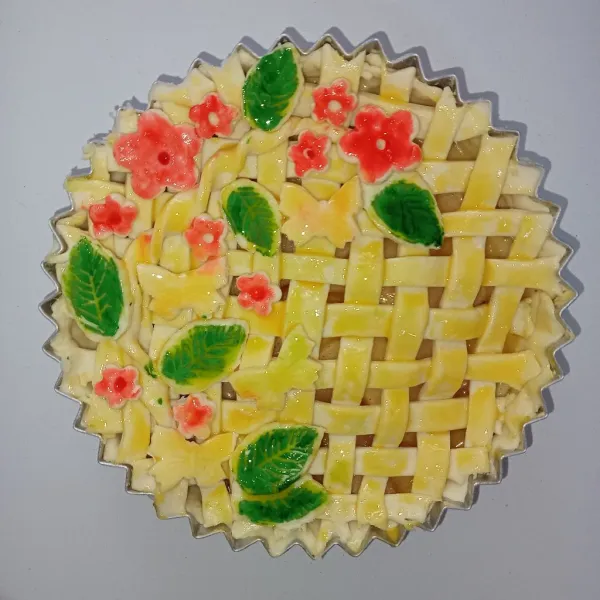 Tambahkan pastry dengan aneka bentuk bunga, kupu dan daun. Olesi pastry dengan kuning telur kemudian tambahkan pewarna sesuai dengan karakter masing-masing.