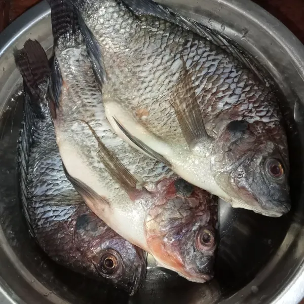 Siapkan ikan, lalu buang sisiknya menggunakan pisau.